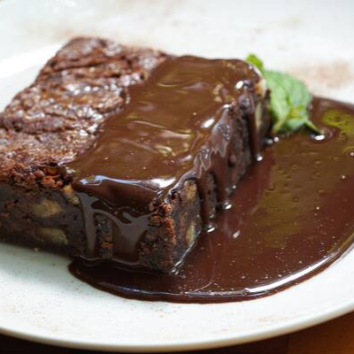 Brownie de chocolate com nozes e calda de chocolate