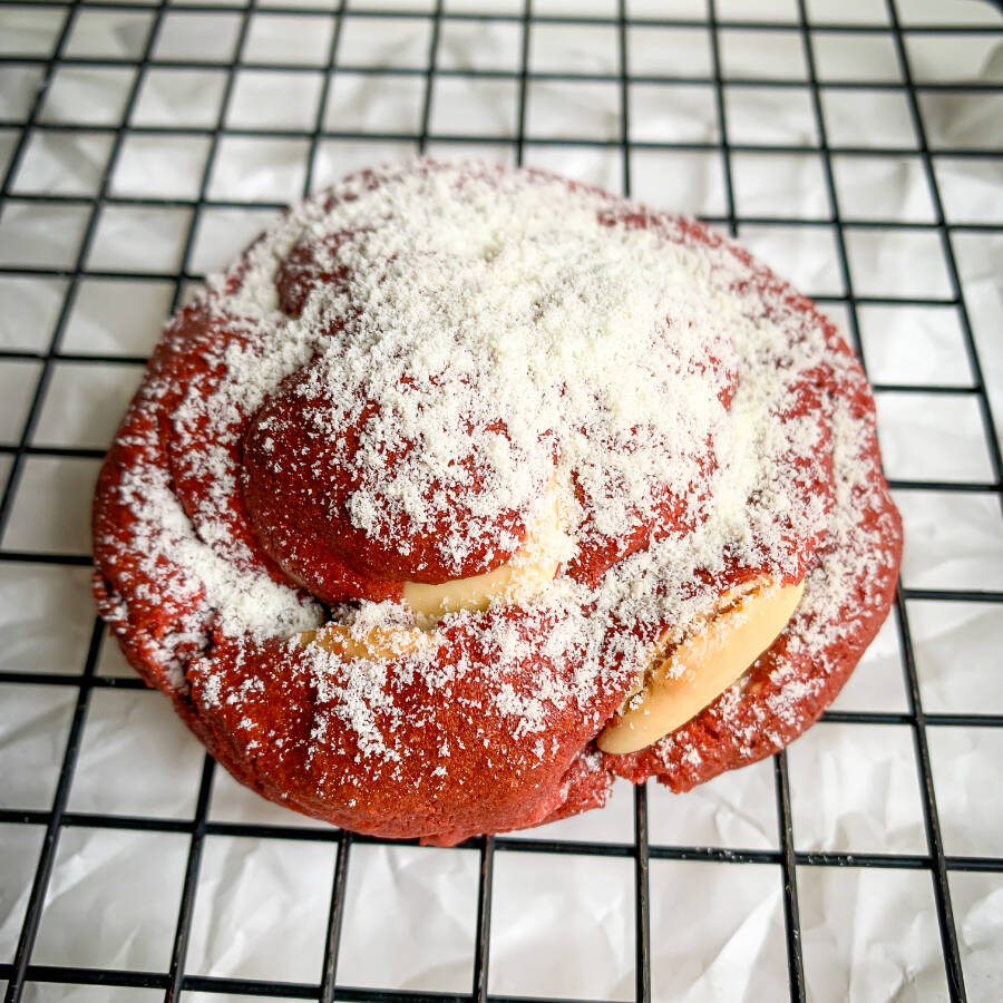 Cookie massa red velvet recheado com brigadeiro de ninho e chocolate branco. Assado na hora!