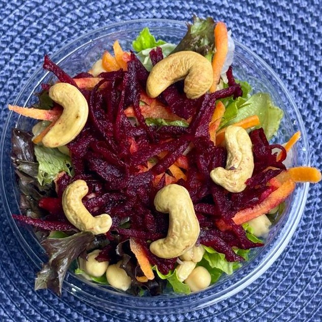 Uma explosão de cores e sabores: mix de folhas, grão-de-bico, cenoura ralada, beterraba e castanhas. 100% vegana, rica em fibras, proteínas vegetais e gorduras boas. Escolha leveza e energia — peça sua salada vegana!