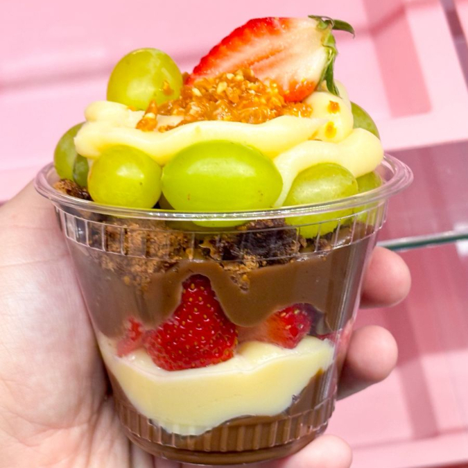 Contem 250ml de brigadeiro ao leite, brigadeiro de ninho, brownie, morango, uva e finalizado com crocante