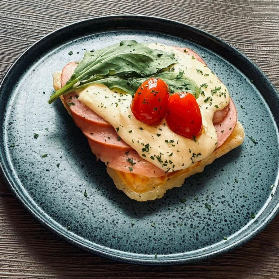 Waffle de pão de queijo, fatias de lombo canadense, creme de queijo e tomate grape confit.