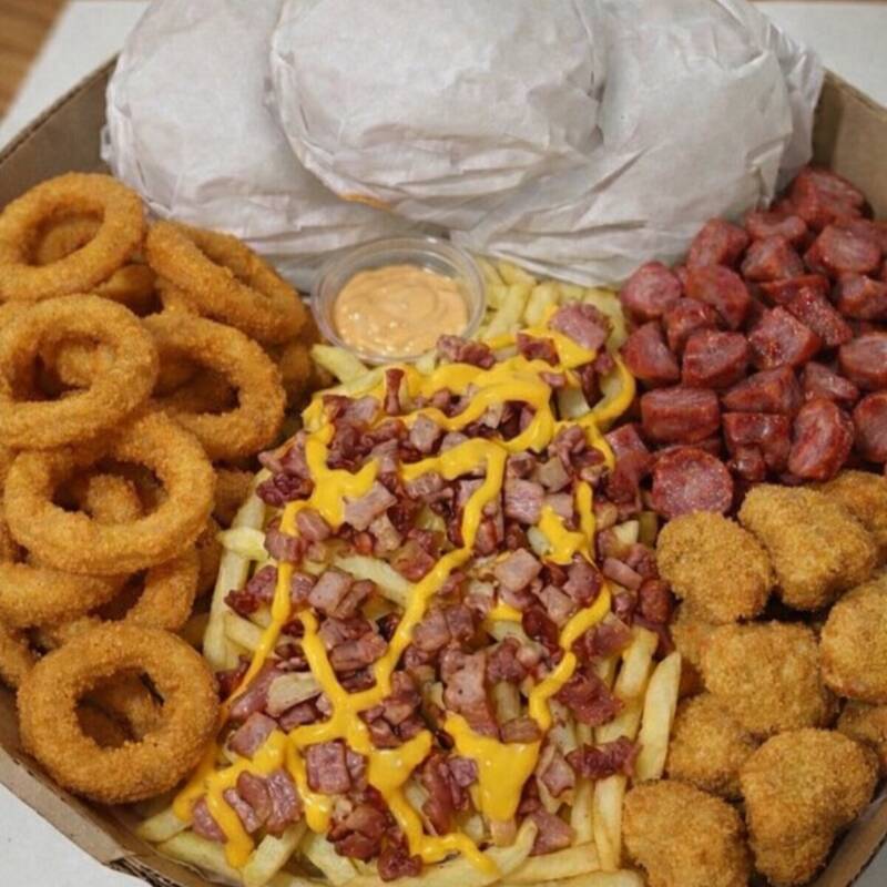 Dois X-Tudo suculentos, bem recheados e feitos na hora 🤤 Acompanhados de: 🍟 Batata frita com bacon e cheddar 🧅 Anéis de cebola crocantes 🌭 Calabresa acebolada 🍗 Nuggets douradinhos 🥫 Molho especial da casa