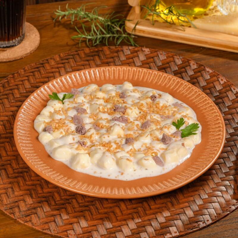 Nhoque de batata com tiras de alcatra, molho Catupiry e Alho frito, criando uma combinação de sabores intensos e irresistíveis.