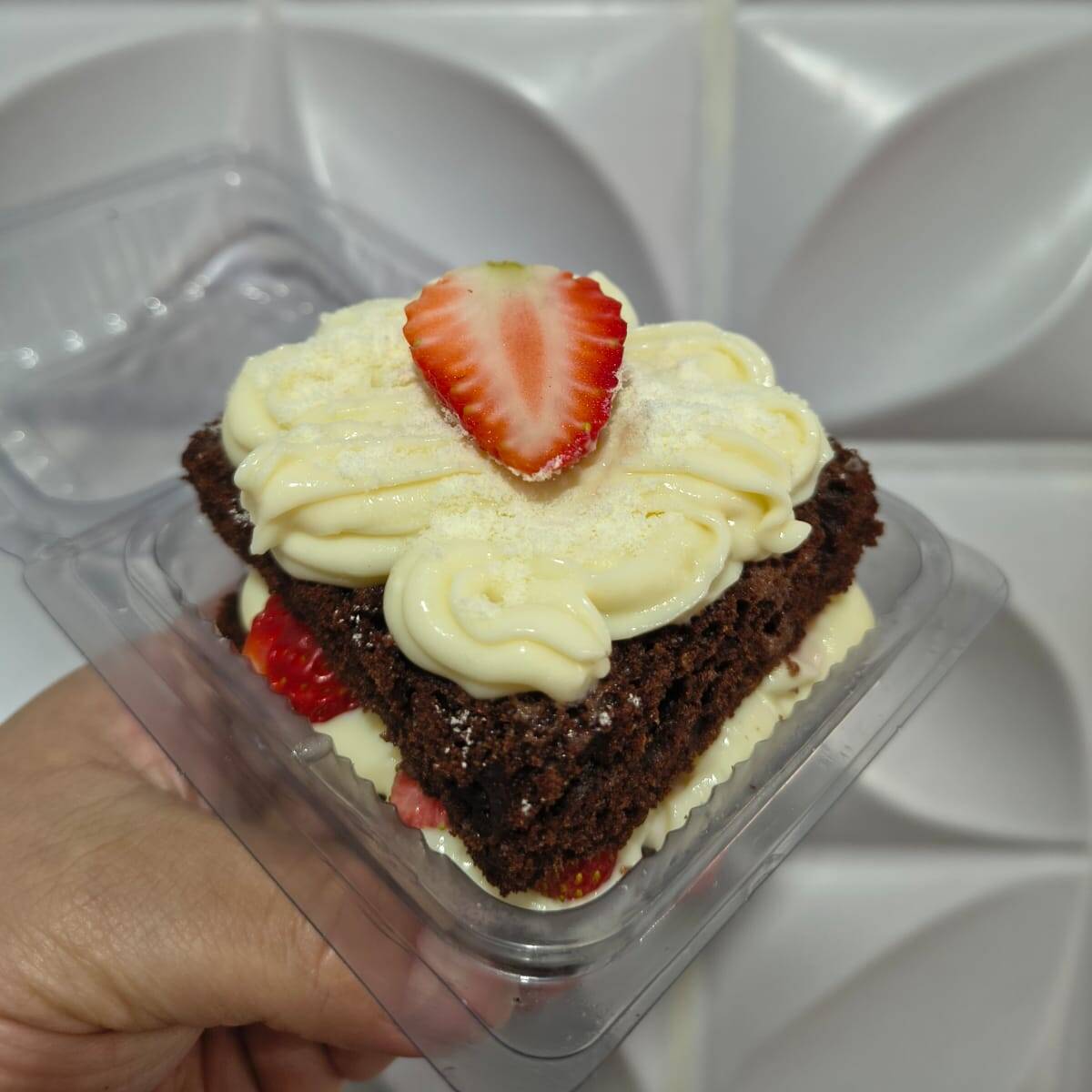Massa de chocolate fofinha, creme de ninho e morangos frescos.