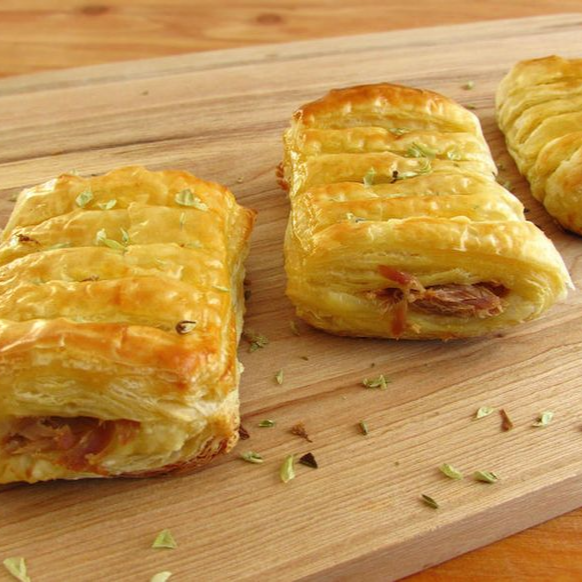 Nossa deliciosa massa folhada especial, leve, douradinha e super crocante, recheada com um irresistível recheio de pernil desfiado com queijo e cebola caramelizada. feito na hora - 06 und. Tamanho festa