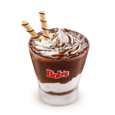 Creme de chocolate com avelã espatulado nas bordas e paredes do copo, mix baunilha, coberto com calda de chocolate, finalizado com uma chuva de leite em pó e dois tubetes crocantes.