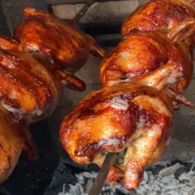 Frango inteiro assado na brasa.