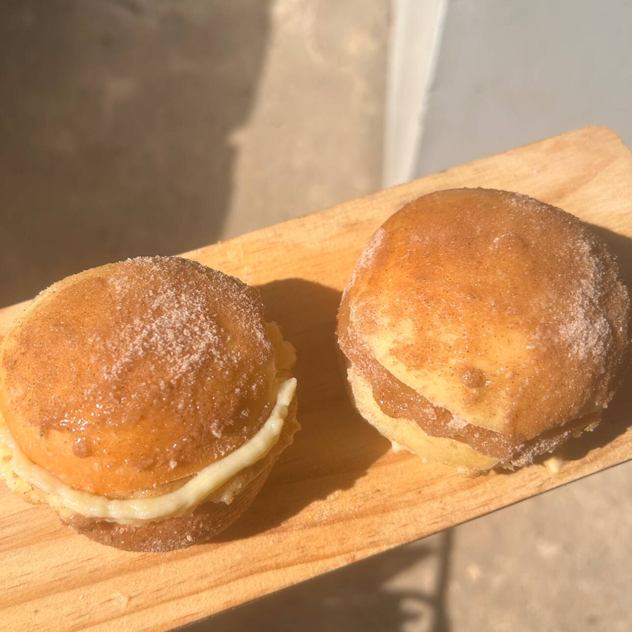 sonho recheado com creme, finalizando com açúcar e canela