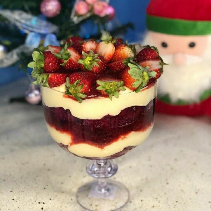 Taça de sobremesa com camadas intercaladas de frutas vermelhas, bolo de baunilha, brigadeiro cremoso de ninho finalizado com morangos. Aproximadamente 1300ML