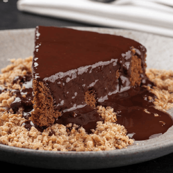 Bolo de chocolate low carb com calda de chocolate zero açúcar e farofa de avelã.