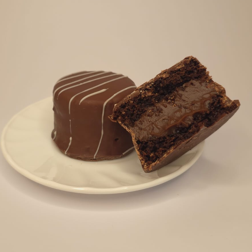 Massa super fofinha com toque de especiarias, recheada generosamente com um cremoso brigadeiro e finalizada com uma casquinha crocante de chocolate ao leite. Equilíbrio perfeito a cada mordida!