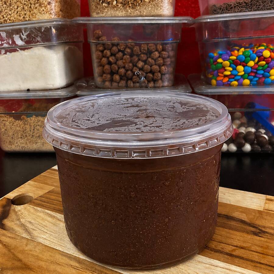 Balde de Açaí Trufado (1l): Uma explosão de sabor e cremosidade! Para os verdadeiros apaixonados por sobremesas, apresentamos o nosso Balde Trufado. Feito para quem busca o máximo de satisfação, ele une a refrescância do nosso açaí premium com a textura aveludada de uma trufa irresistível, espalhada generosamente pelo balde. Um contraste surreal que transforma cada grama em um momento de puro prazer. Personalize seu momento: Adicione seus acompanhamentos favoritos e experimente a combinação com sorvete para uma cremosidade ainda mais incrível. Aberto o balde, é impossível comer um pouco só!