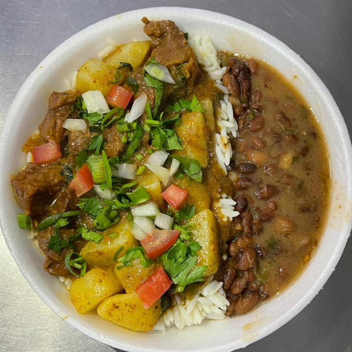 Carne bovina cozida com batata, acompanhada de arroz, feijão e farofa.