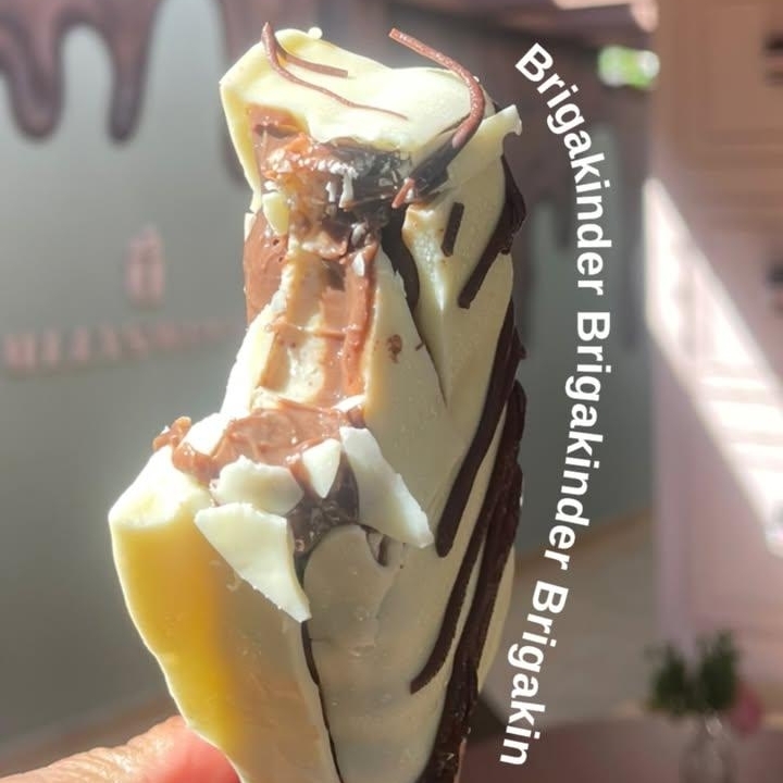 Um gelato de brigadeiro irresistível, recheado com um cremoso creme de Kinder e delicadamente banhado em chocolate branco. A combinação perfeita entre o sabor intenso do brigadeiro e a suavidade do Kinder proporciona uma experiência de sabor única. Ideal para quem busca um doce que une tradição e inovação. Experimente essa delícia que derrete na boca e traz um toque especial a qualquer momento.