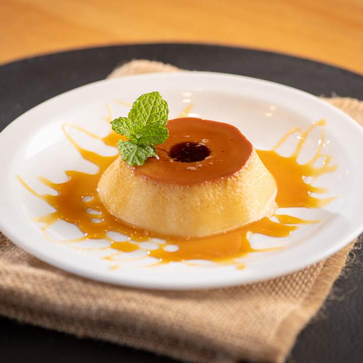 Pudim cremoso e que derrete na boca. Finalizado com calda de caramelo e hortelã.