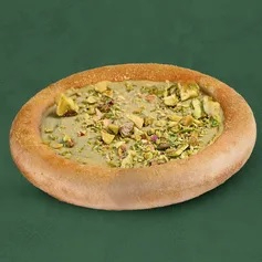 Massa macia de esfiha recheada com creme de pistache, finalizada com grãos crocantes de pistache por cima para dar textura e sabor.