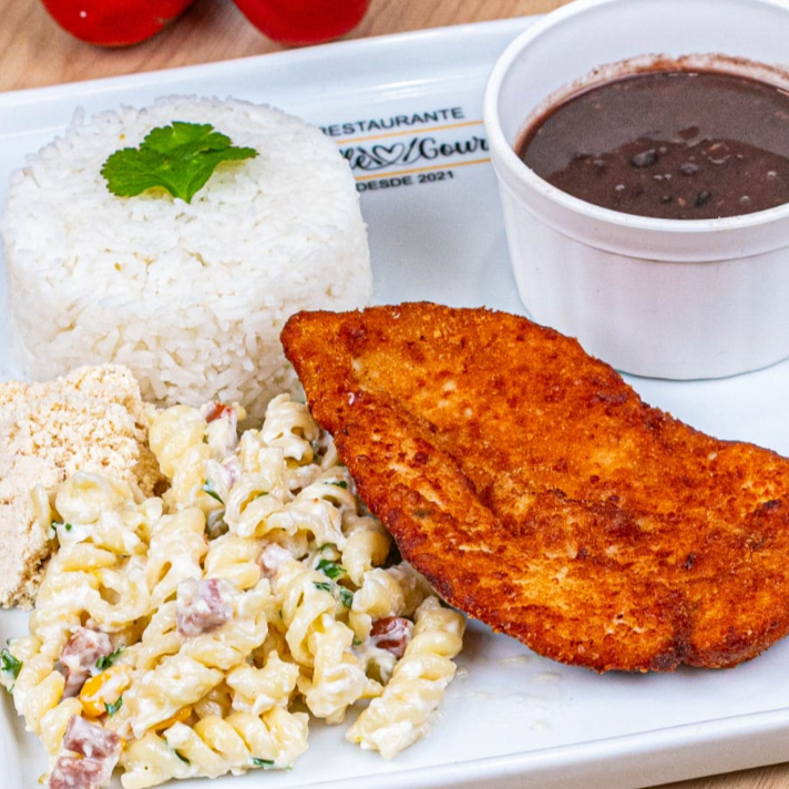Saboroso Filé de Frango á milanesa com Salada de Macarronese, acompanhado por um arroz branco soltinho, um feijão caseiro repleto de sabor, farofa crocante. Todos esses itens são servidos em uma prática marmita com aproximadamente 600gr, nossa embalagem vai ao microondas.