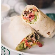 Frango marinado no pão folha, tomate, repolho finíssimo. picles de pepino, pesto de azeitonas pretas e molho toum.