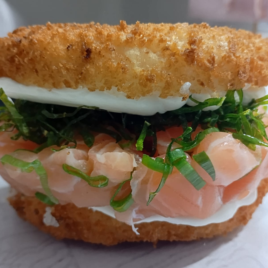 Arroz japonês com cream cheese, empanado na panko e frito. Recheio: Salmão em cubos, cebolinha, cream cheese e couve crispy.