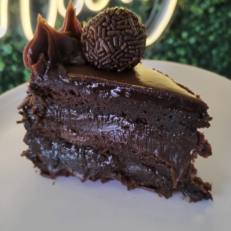 Massa de chocolate, com recheio de brigadeiro e cobertura de ganache de chocolate e granulados. Peso da fatia aprox 180g.