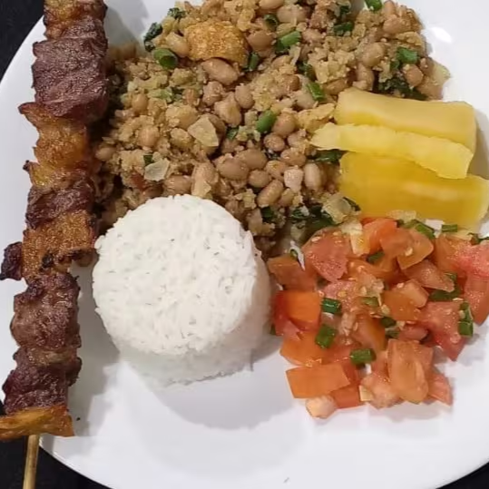 Nossa jantinha acompanha arroz branco soltinho, feijão tropeiro especial da casa, vinagrete fresquinho do dia e mandioca cozidinha derretendo + 1 espetinho a sua escolha, totalizando aproximadamente 800g de muito sabor.