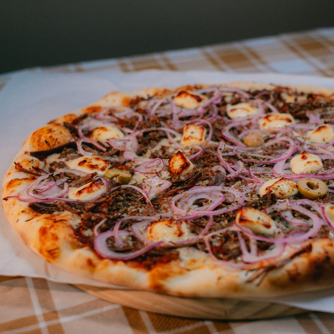 Uma explosão de sabores regionais! A suculência da carne de sol desfiada encontra a cremosidade da muçarela e o toque dourado do queijo coalho. As cebolas finalizam o prato trazendo um leve adocicado que harmoniza perfeitamente com o salgadinho da carne.
