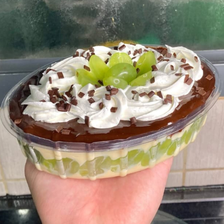 Uvas Thompson sem caroço, uma camada do nosso delicioso creme de Ninho e uma camada do nosso creme de chocolate 50% cacau, finalizado com chantilly, uvas e granulado de chocolate nobre. Travessa 1L