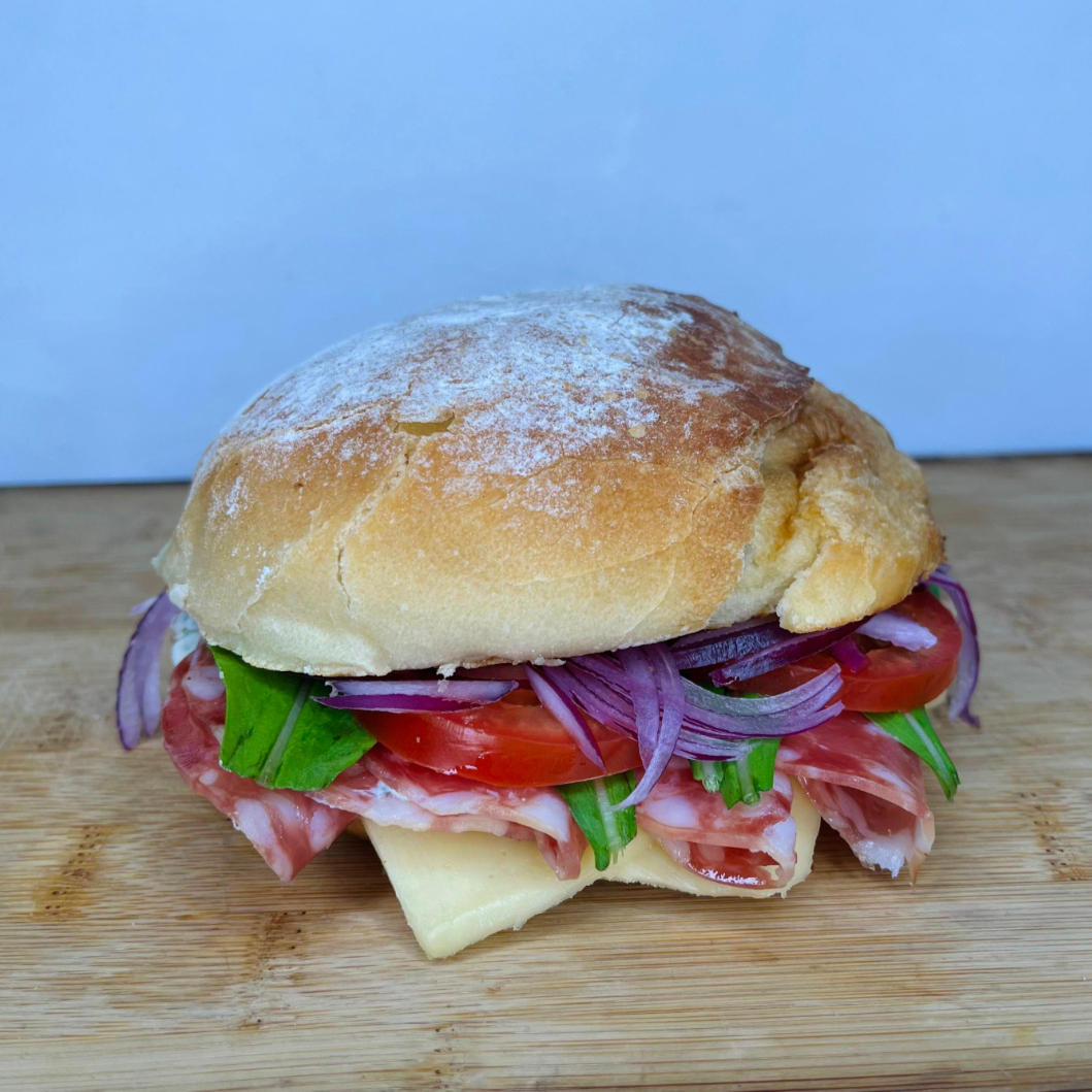 Creme de ricota temperado, salame fatiado tipo Italiano, queijo prato, rúcula fresca, tomate suculento e cebola roxa, tudo servido em um pão de fermentação natural super macio. Uma combinação perfeita de textura e sabor!