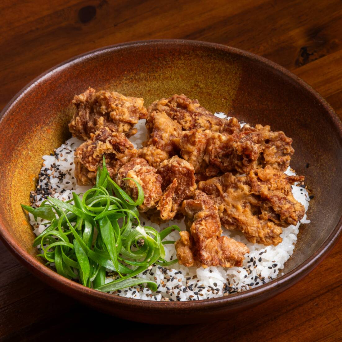 Arroz gohan, com karaague (frango japonês marinado e empanado), finalizado com cebolinha fresca.