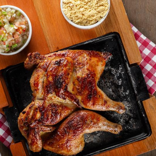 Delicioso Galeto assado na brasa, acompanhado de vinagrete e farofa.