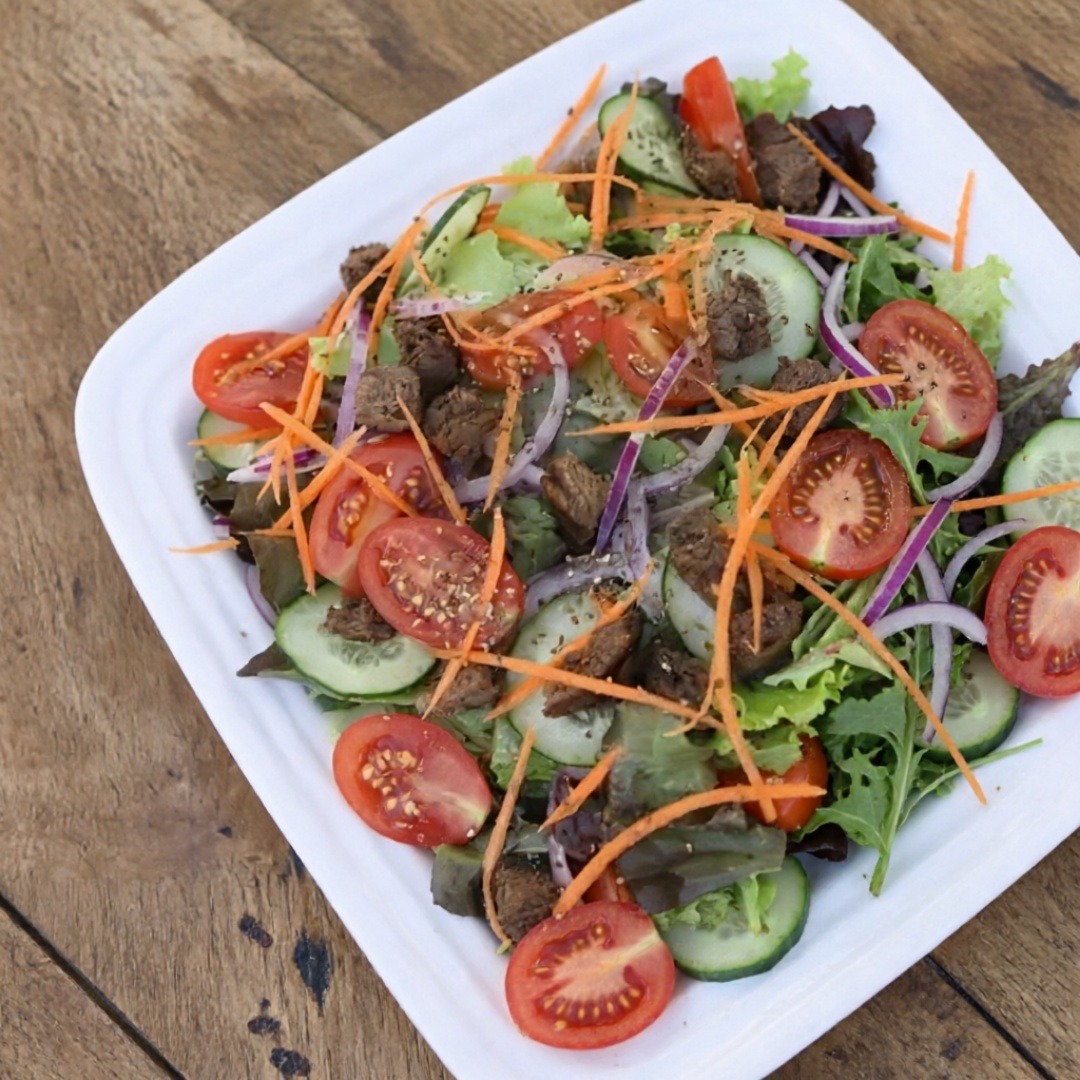 Uma salada super deliciosa com alface americana, tomatinho cereja, cebola roxa, pepino japonês, rolet de cenoura, parmesão e crótons.