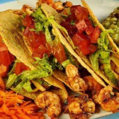 Três crocantes tortillas de milho abertas em meia lua, recheada com queijo, alface e tomate.