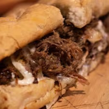 Sanduíche de costela desfiada, temperada e suculenta, servida em pão macio, uma explosão de sabores em cada mordida.