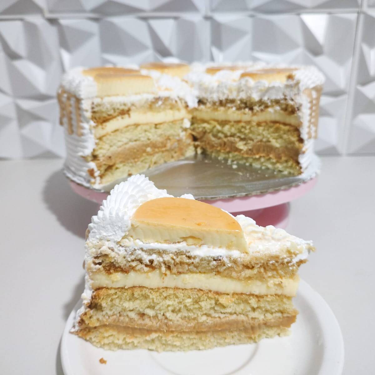 Fatia de Torta Pudim com Doce de Leite: massa fofinha de baunilha, camadas cremosas de pudim e um recheio generoso de doce de leite. Uma fatia geladinha, cremosa e irresistível para quem quer uma sobremesa de verdade.