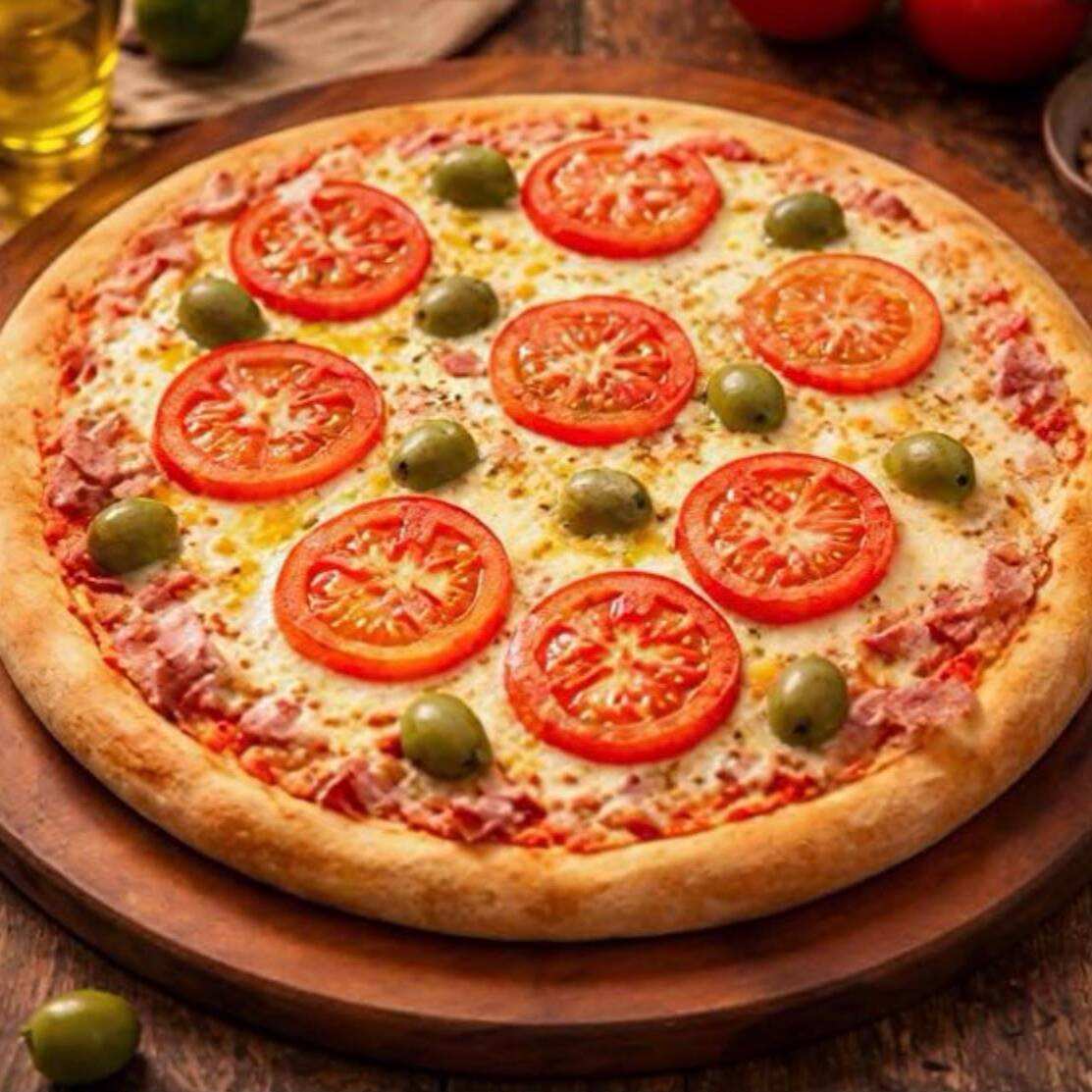 Nossa pizza Bauru é preparada com uma massa artesanal, leve e macia por dentro, molho de tomate, presunto, mussarela derretida e rodelas de tomate fresco, finalizada com um toque especial de orégano.
