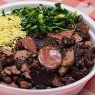 Feijoada típica do Rio de Janeiro, feita com feijão preto, carnes variadas e acompanhamentos tradicionais como arroz, farofa e laranja.