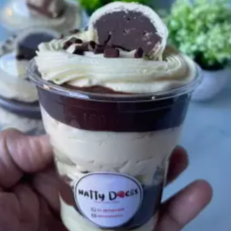 Imagine camadas generosas do nosso brigadeiro gourmet artesanal, incrivelmente cremoso, intercaladas com um creme de Leite Ninho aveludado e fresquinho. No coração do copo, adicionamos o delicioso bombom Ouro Branco picado entre os recheios e, para finalizar com chave de ouro, o topo recebe um toque leve de chantininho, granulé de chocolate ao leite e mais pedaços generosos de bombom. É aquela colherada perfeita que mistura a cremosidade com a crocância irresistível do Ouro Branco!