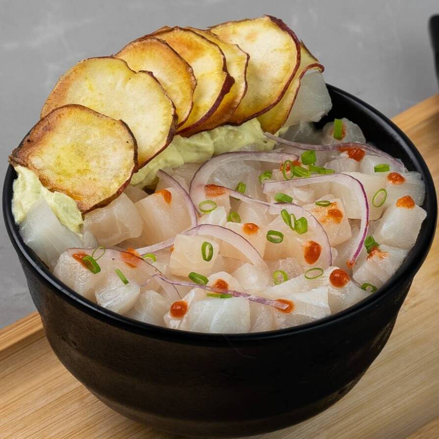 Cubos de tilápia temperados em molho especial de limão, molho de pimenta chilli, cebola roxa e cebolinha, servidos com mousse de avocado e chips de batata doce - Aprox. 142g.