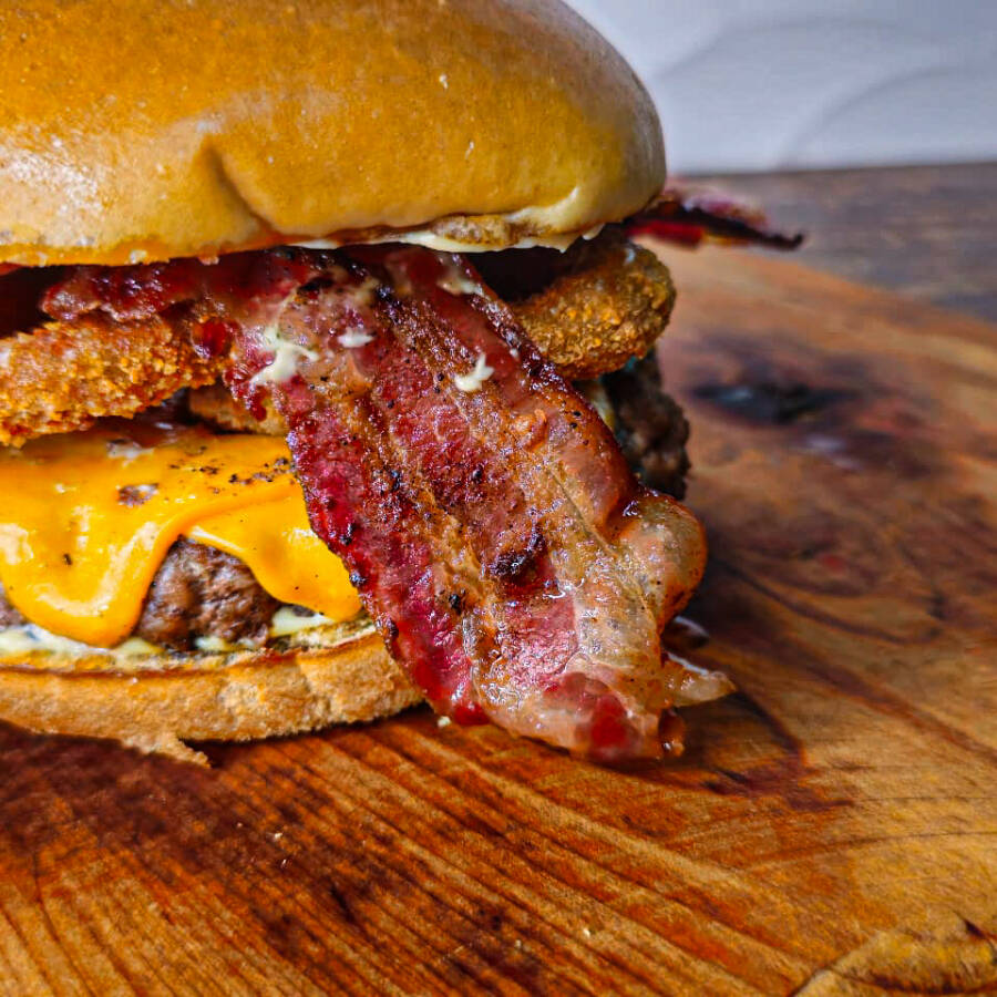 1 burguer Artesanal de 140g, 2 fatias de queijo mussarela, cebola Onion, maionese artesanal no pão de gergelim