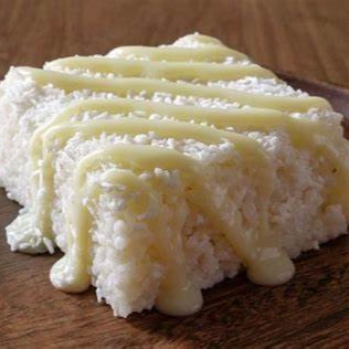 Delicioso cuscuz de tapioca com coco ralado fresco, regado com leite condensado à gosto. Peso aproximado de 190 gramas.