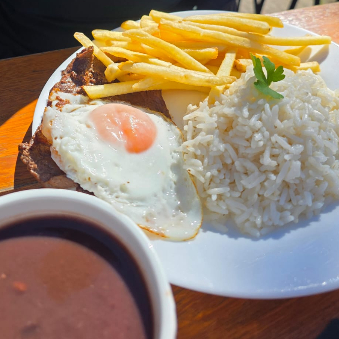 Arroz branco, feijão, bife bovino acompanhado de ovo frito e batata frita