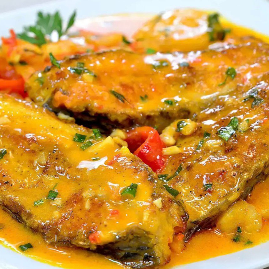 Peixe cozido em molho de leite de coco, oferecendo um toque suave e cremoso.