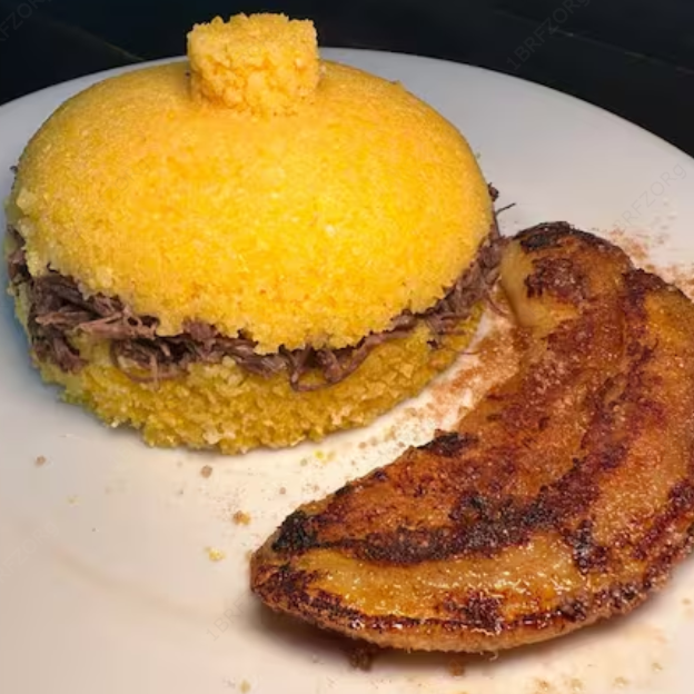 Cuscuz fofinho, carne de sol desfiada, queijo coalho ralado e banana frita com açúcar e canela.