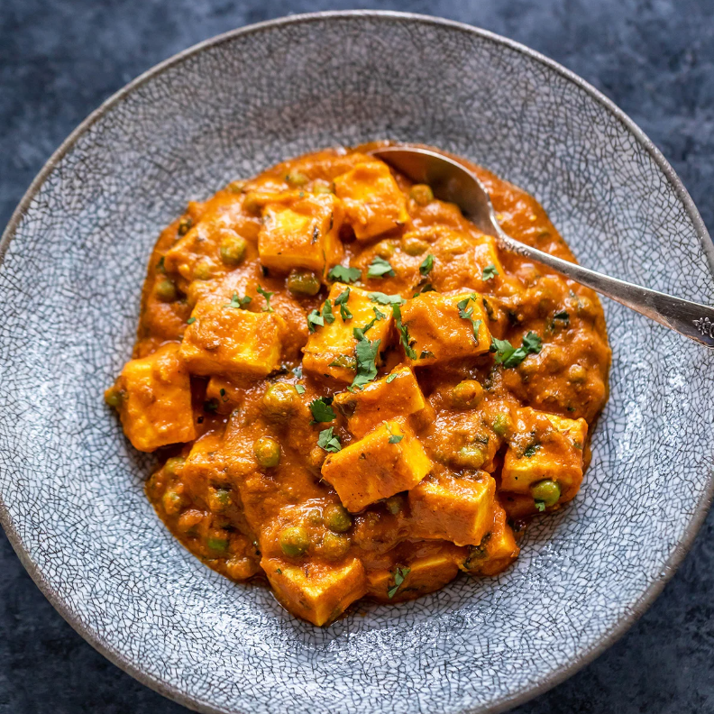 Cubos de ricota e ervilhas cozidas em molho suave e cremoso feito com castanha de caju, tomates frescos, condimentos e ervas indianas.
