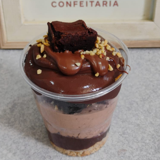 Copo com camadas de mousse de Nutella, creme de chocolate 50%, brownie, amendoim picadinho e avelã. Finalizado com Nutella. Atenção alérgicos: Possui Amendoim.