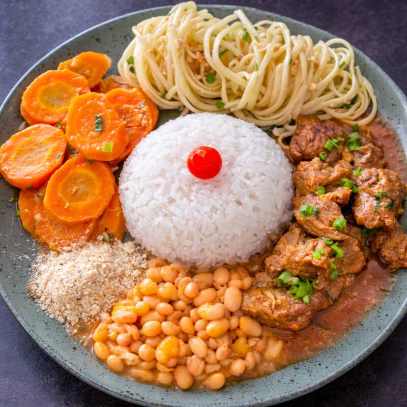Carne de panela acompanhada de macarrão alho e óleo, cenouras salteadas na manteiga e farofa.