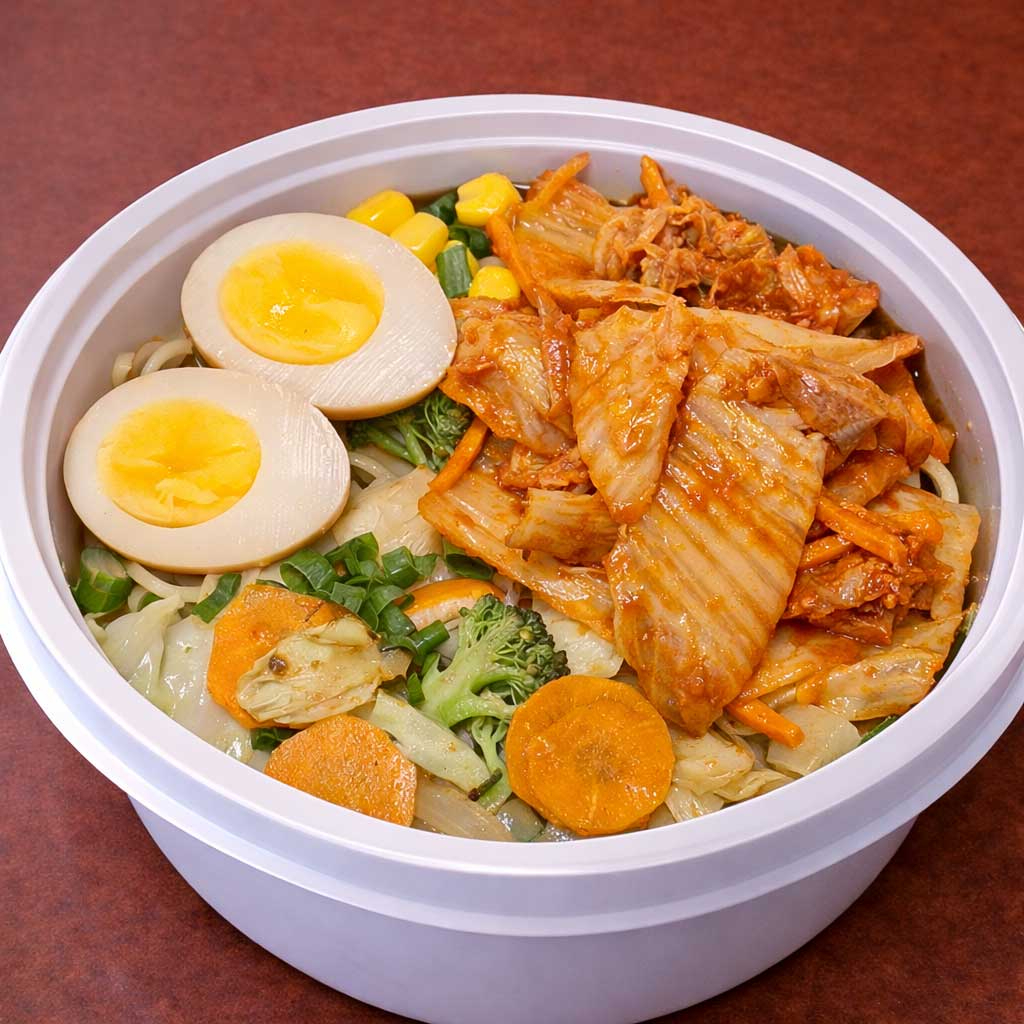 Misso lamen kimuchi vai acelga coreana picante, ovo com gema cremosa, legumes refogados, uma fatia de tyashu (copa lombo). O caldo vai em uma embalagem separada para conservar a qualidade dos ingredientes, principalmente a massa do lamen. (imagem ilustrativa) Nosso misso lamen é preparado com o caldo de galinha de produção própria que leva mais de 6 horas para ficar pronto. Também na pasta de misso são acrescentados mais 10 temperos japoneses e orientais para acrescentar mais sabor ao caldo. A massa utilizada tem 30cm de comprimento seguindo a tradição dos melhores lamenyas do Japão, inclusive com farinha de trigo importada. O resultado é um lamen preparado com muito cuidado e carinho e com sabor que irá surpreender.