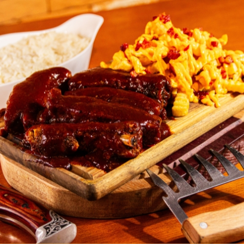Costelinha barbecue, coberta com um molho barbecue caseiro. Acompanhada de arroz , e batatas fritas cobertas com uma camada de cheddar derretido e pedaços crocantes de bacon.