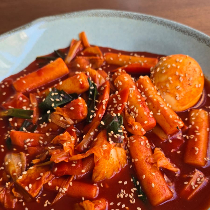 Tteokbokki é o famoso street food coreano (comida de rua), feito com bolinhos de arroz (Tteok) em um molho picante à base de Gochujang (pasta de pimenta coreana). Esse é picante ️️️