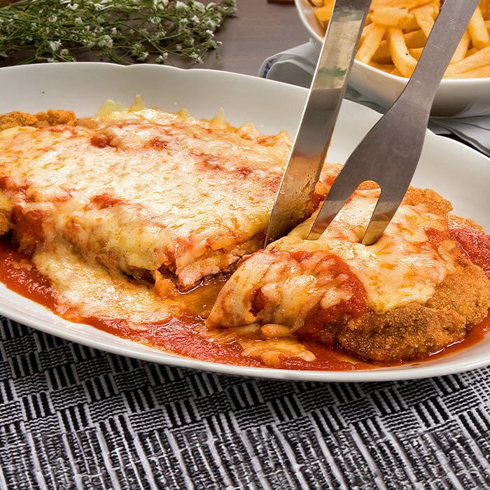 Sabor tradicional italiano: Suculento filé de frango empanado, envolvido em molho de tomate temperado e finalizado com queijo gratinado no forno. Acompanhado de arroz e salada fresca.